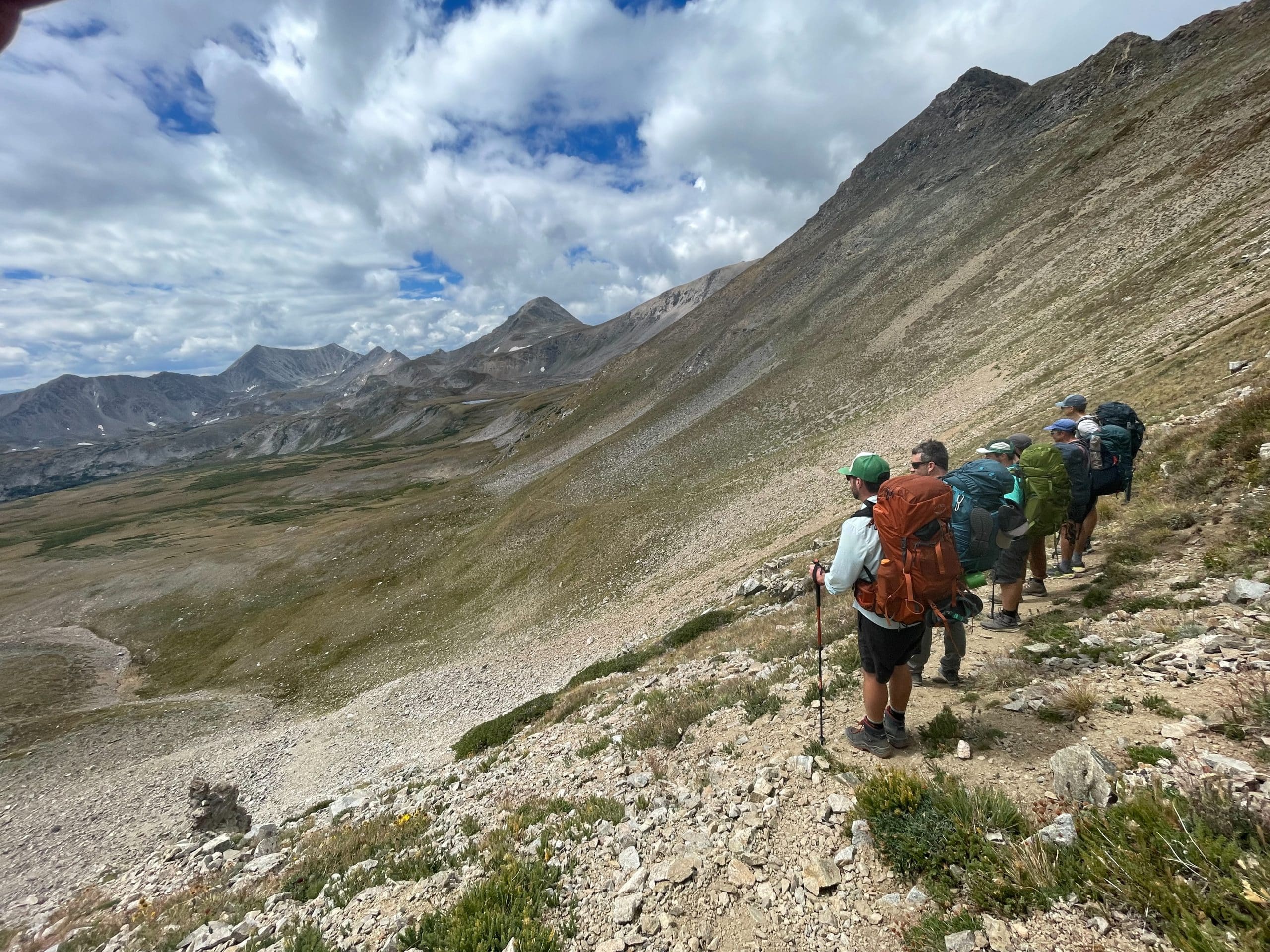 Backpackers looking out over a mountain vista wearing Osprey backpacks.