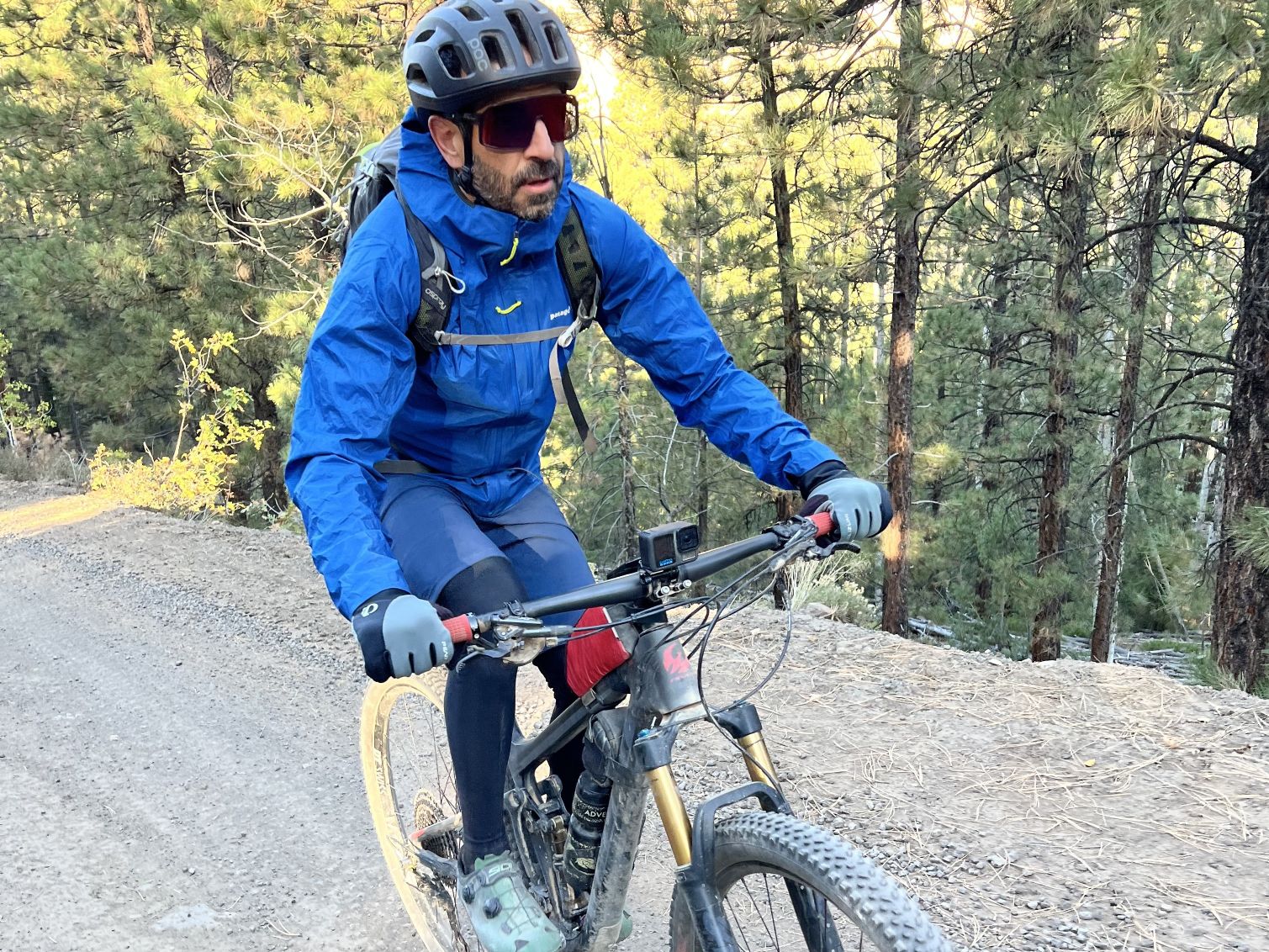 A mountain biker wearing the Patagonia Stormracer jacket