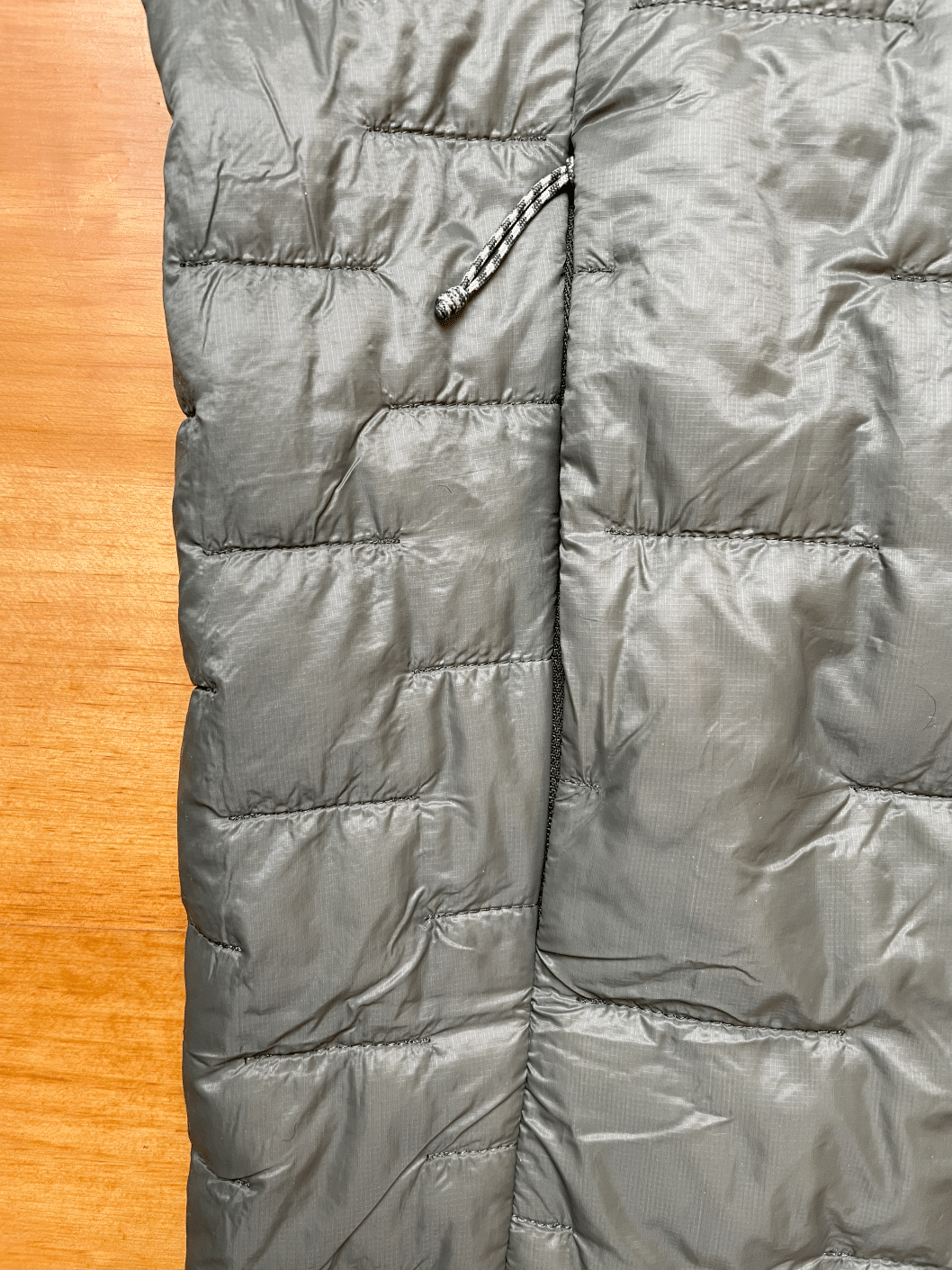 Closeup image of the Patagonia Micro Puff jacket handwarmer pocket zipped closed.