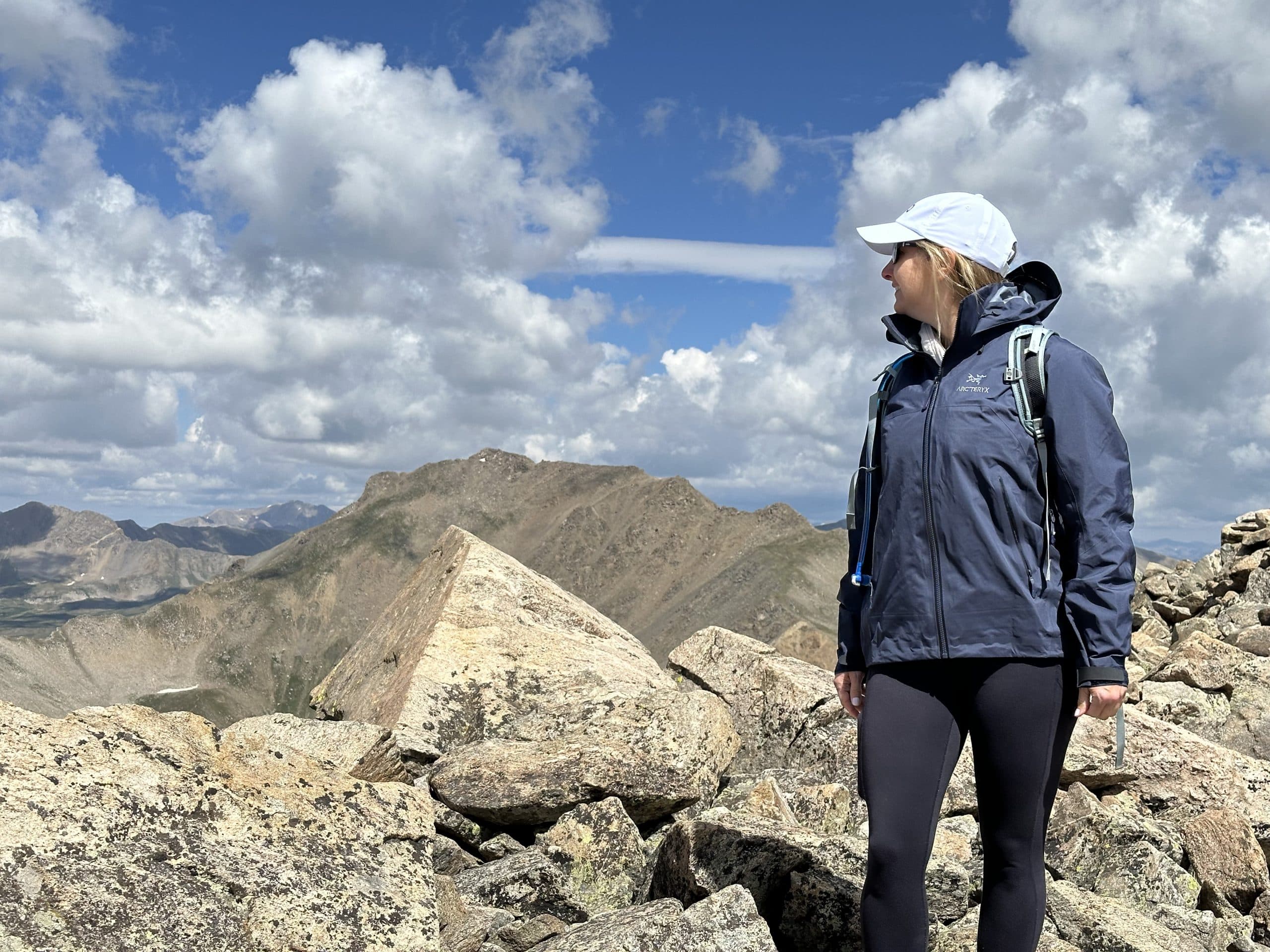 A women wearing an Arc'teryx Beta AR jacket as she summits a Colorado 14er