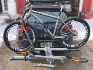 A Moots mountain bike on a Kuat hitch rack, mounted to a VW GTI.