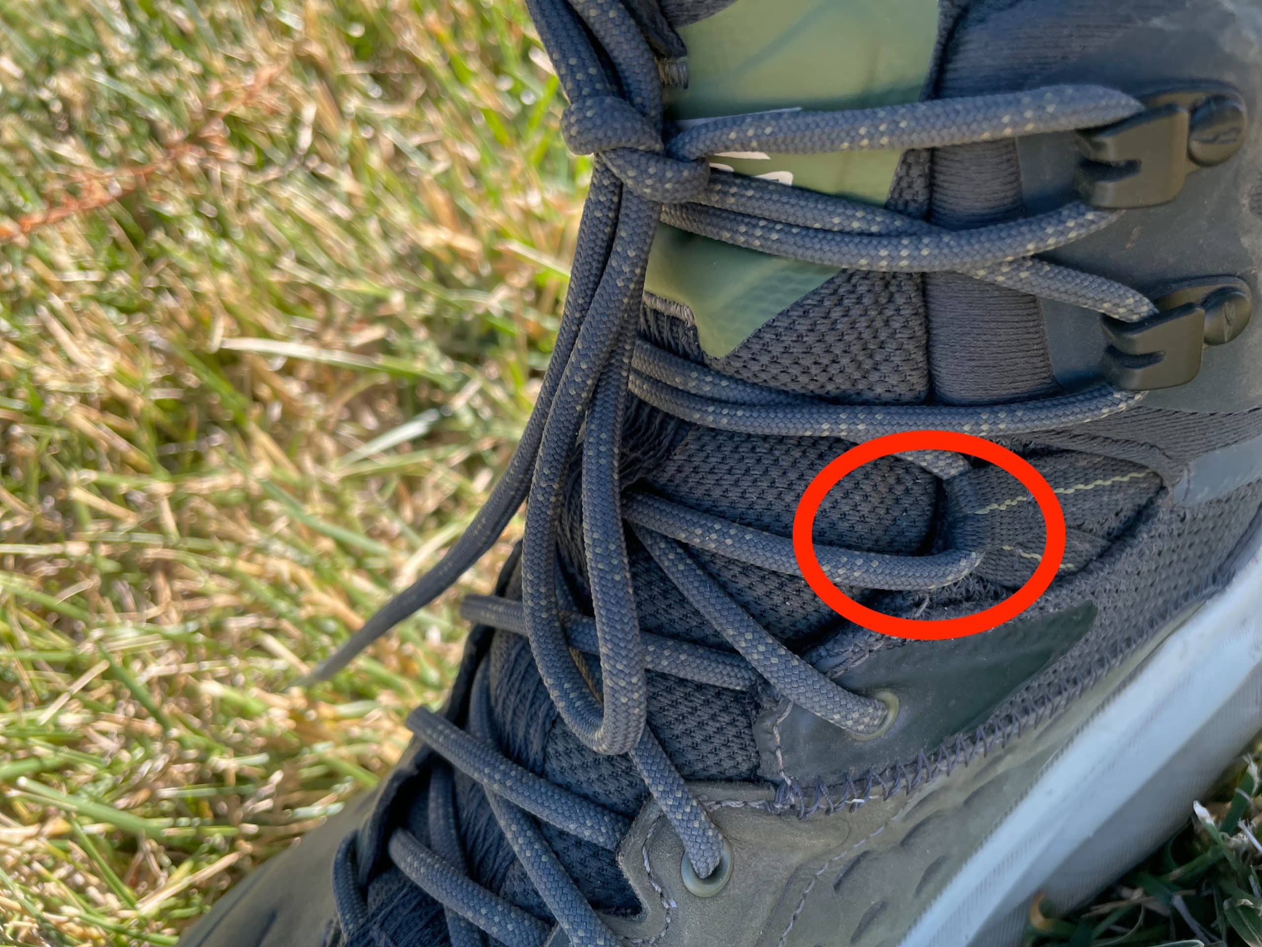 A closeup image showing an issue with the construction of the Altra Olympus 6 Hike Mid GTX boot lacing.