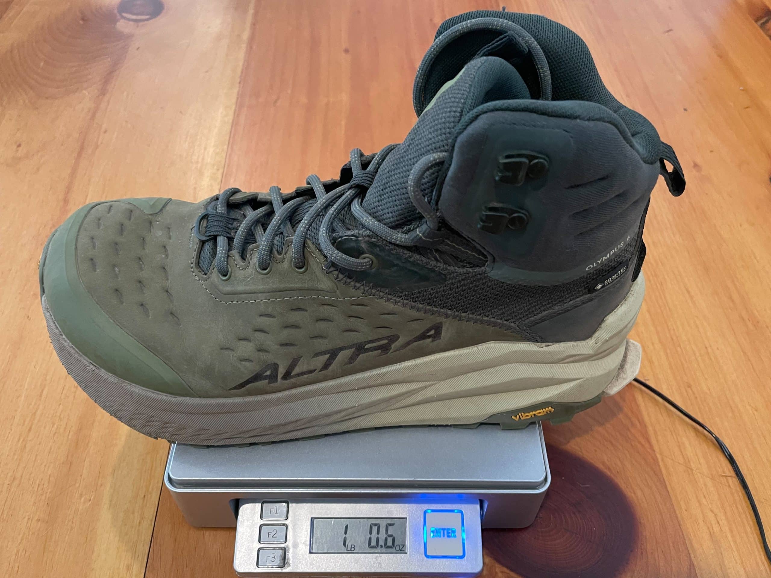 The Altra Olympus 6 Hike Mid GTX mens boot being weighed on a scale.
