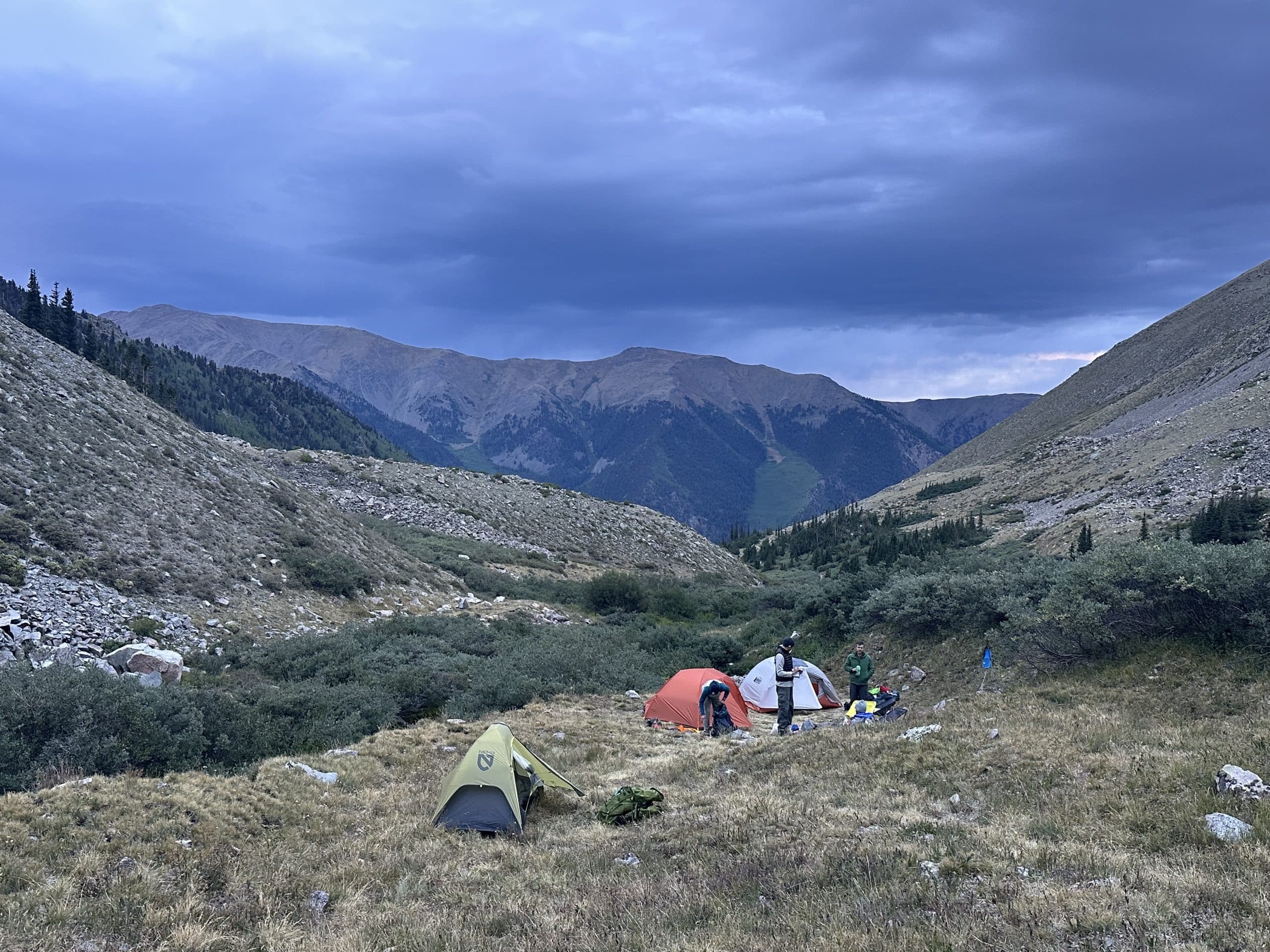 Ultralight backpacking tents pitched in the mountains with a stormy sky.