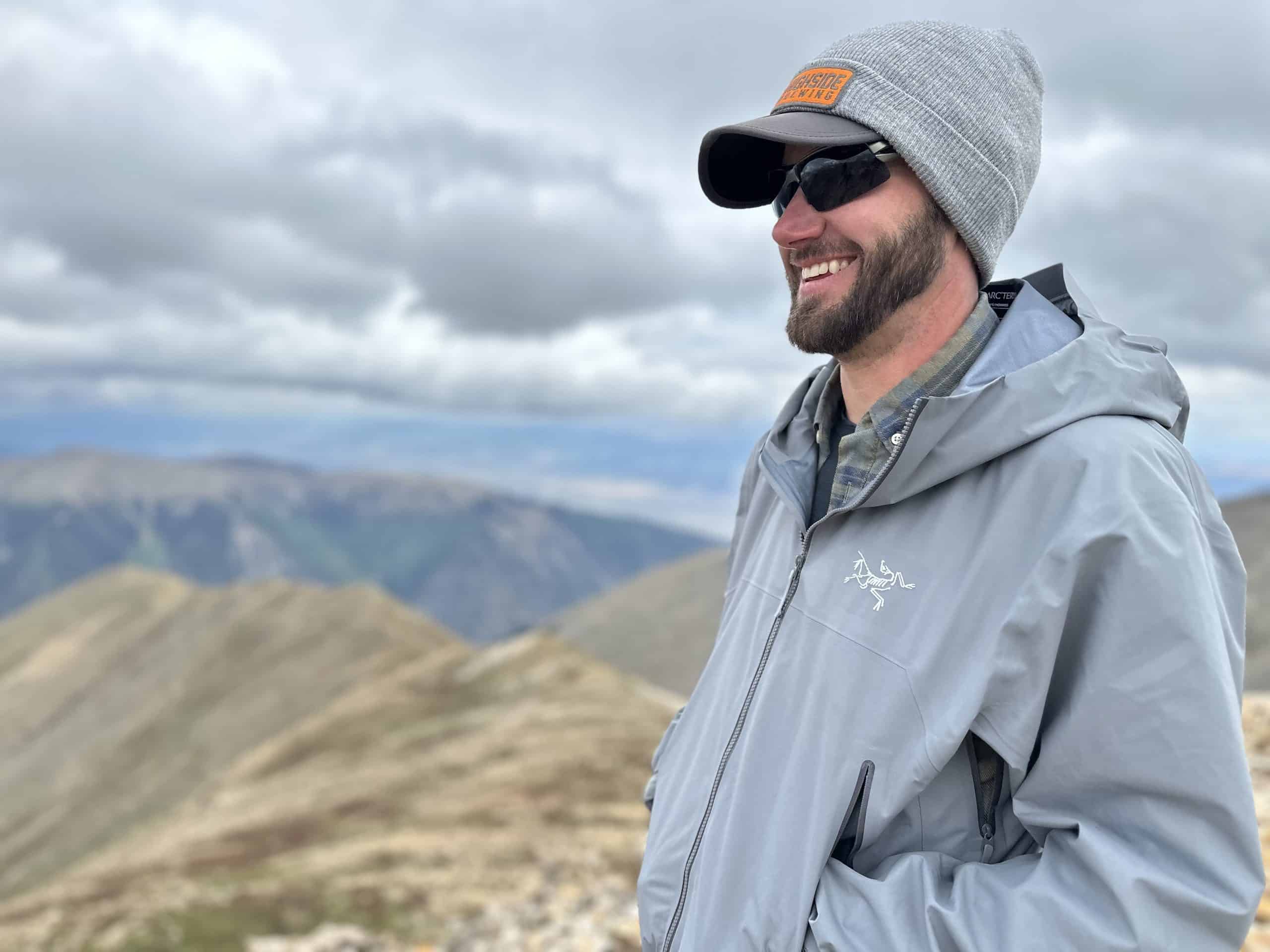 Hiker wearing the Arc'teryx Beta SL jacket on a mountain top.