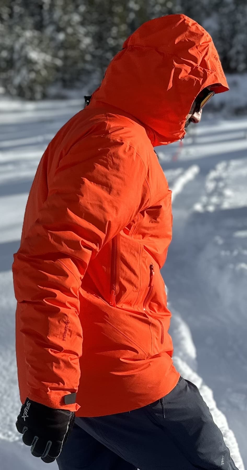 Man wearing a red Arc'teryx Beta Insulated Down Jacket in snow.