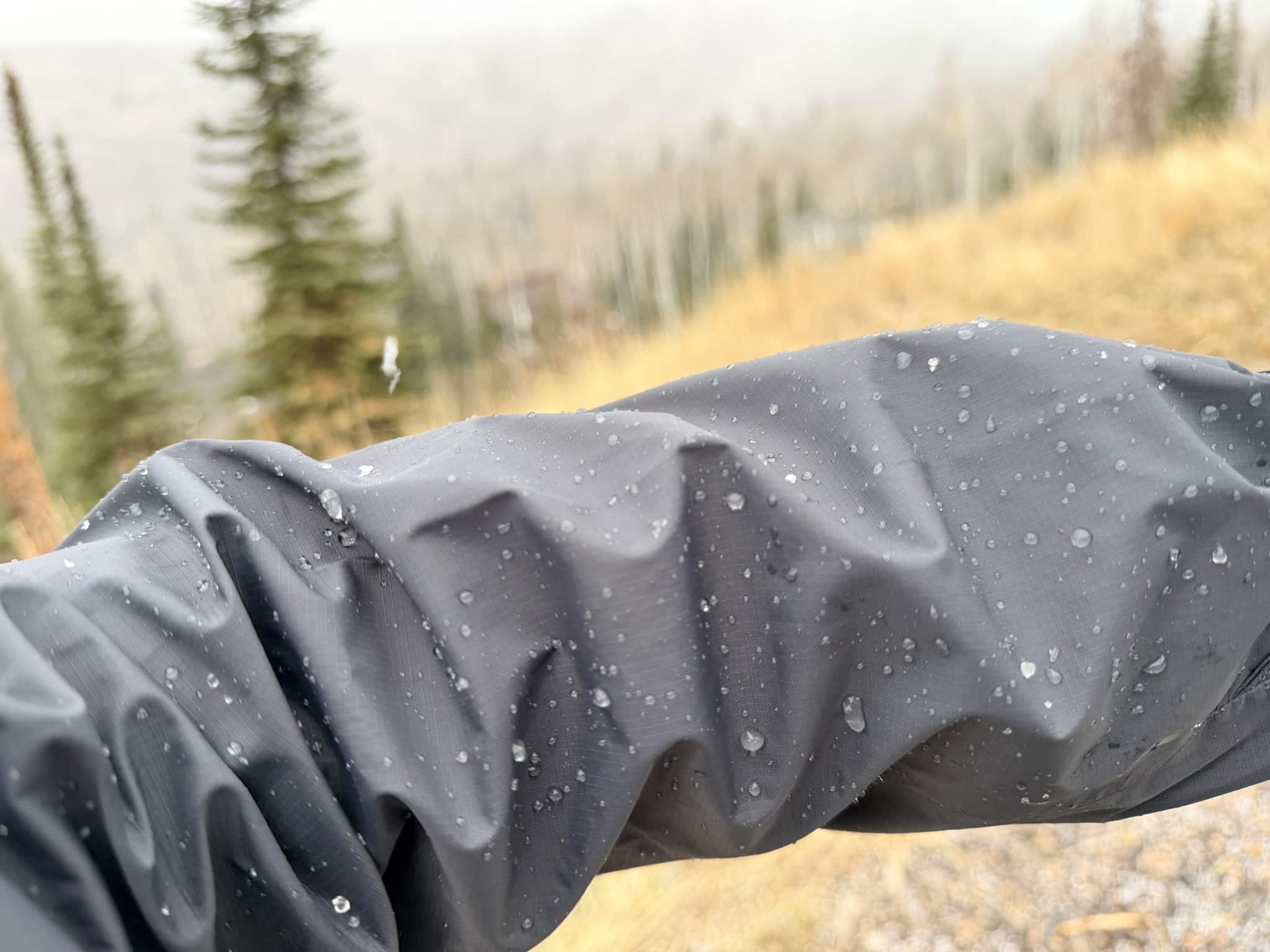 The sleeve of a Patagonia Torrentshell 3L rain jacket showing water beading up on the fabric.
