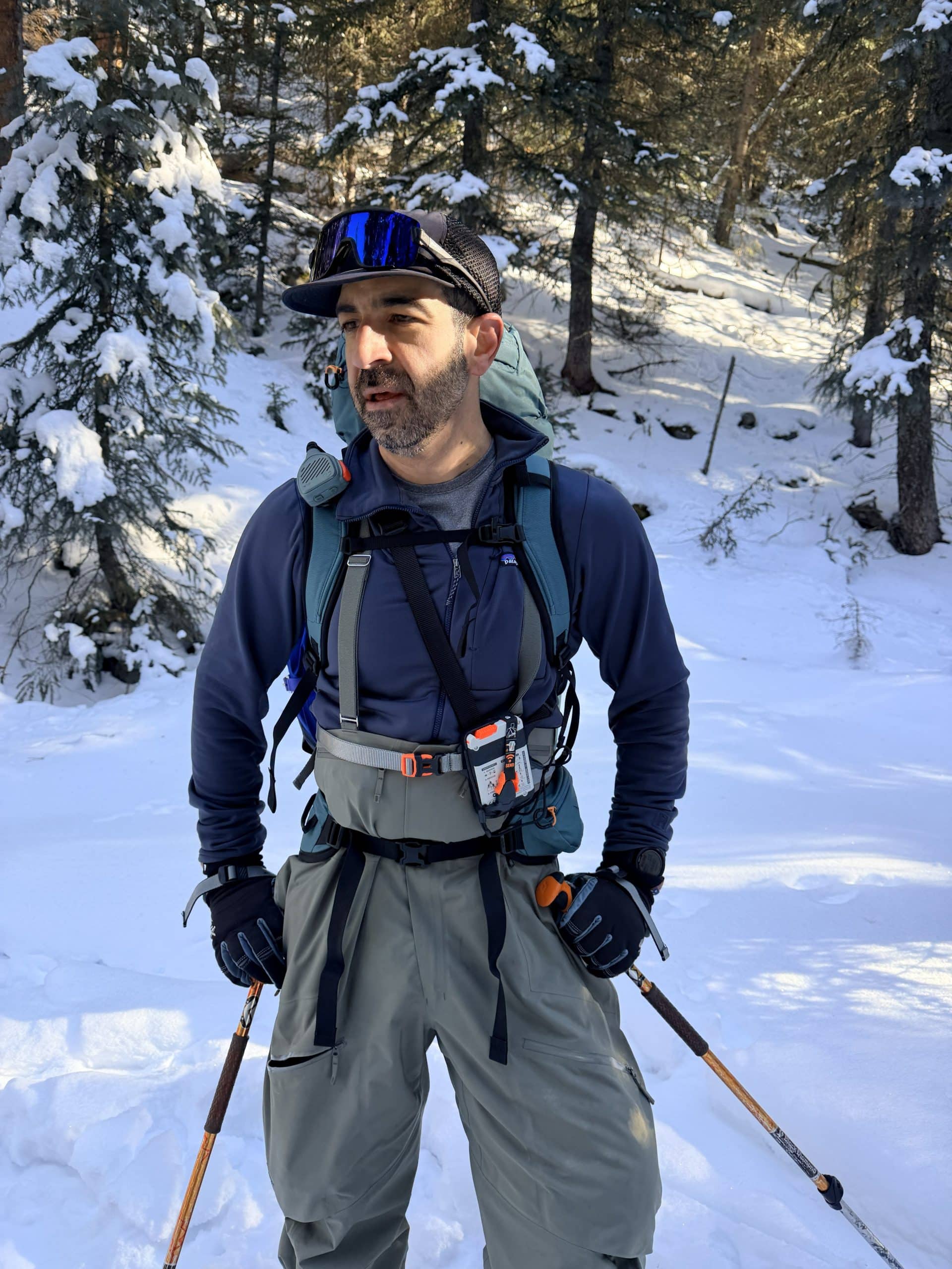 A skier wearing the Osprey Soelden 45L ski pack while ski touring.