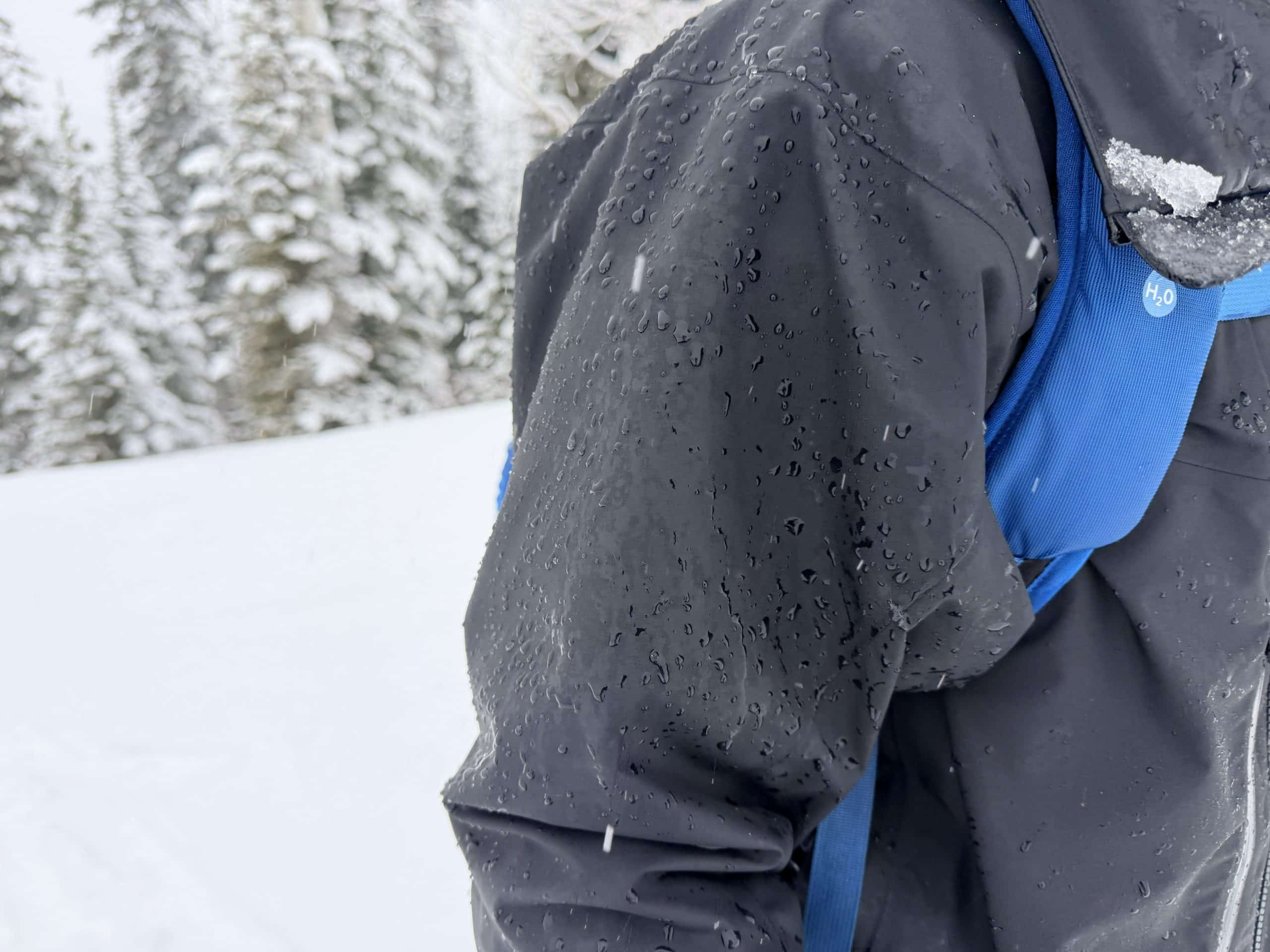 The Arc'teryx Alpha SV jacket with snow melting on the sleeve.
