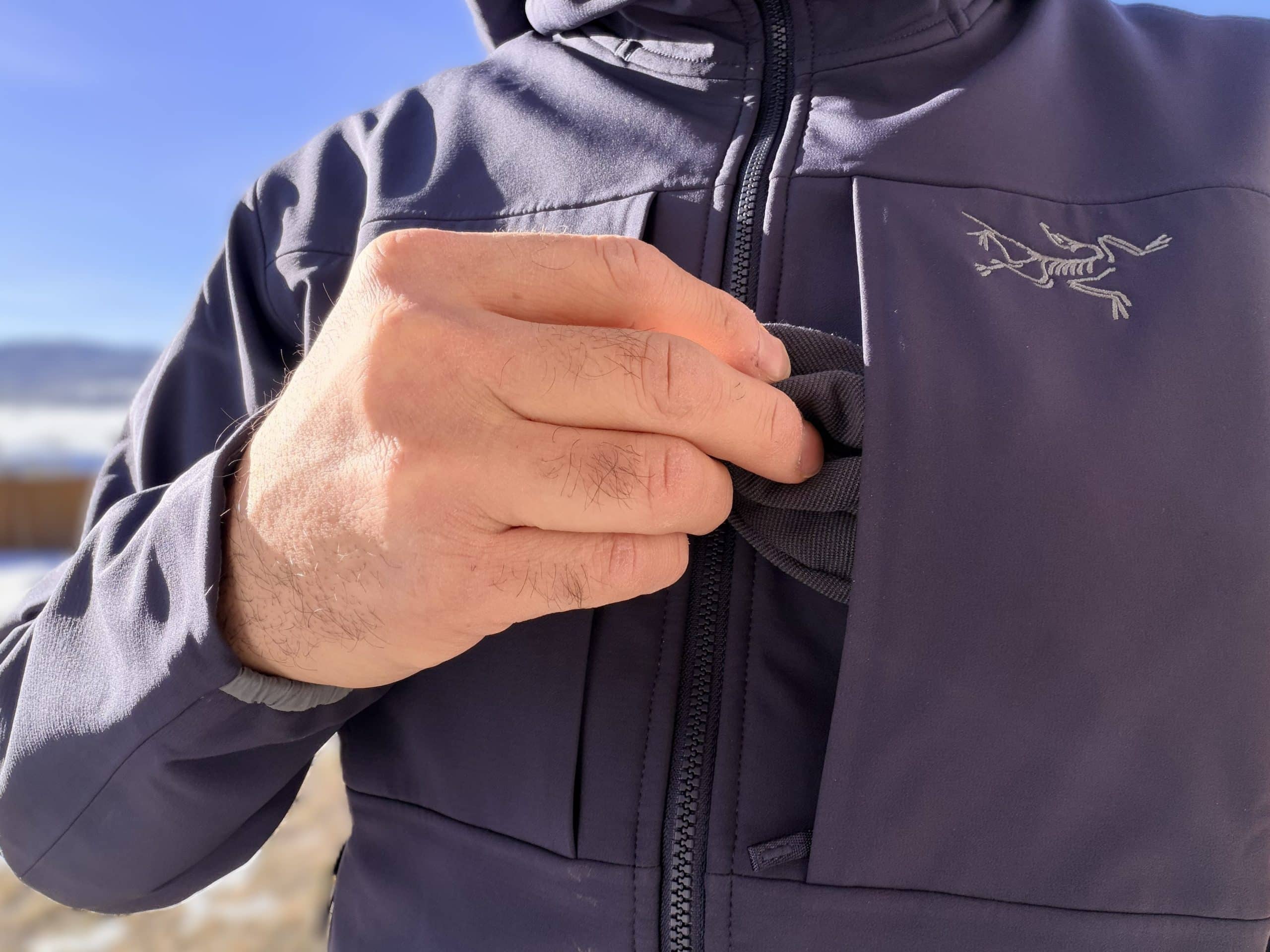 Taking a beanie out of the chest pocket of an Arc'teryx Gamma MX Hoody.