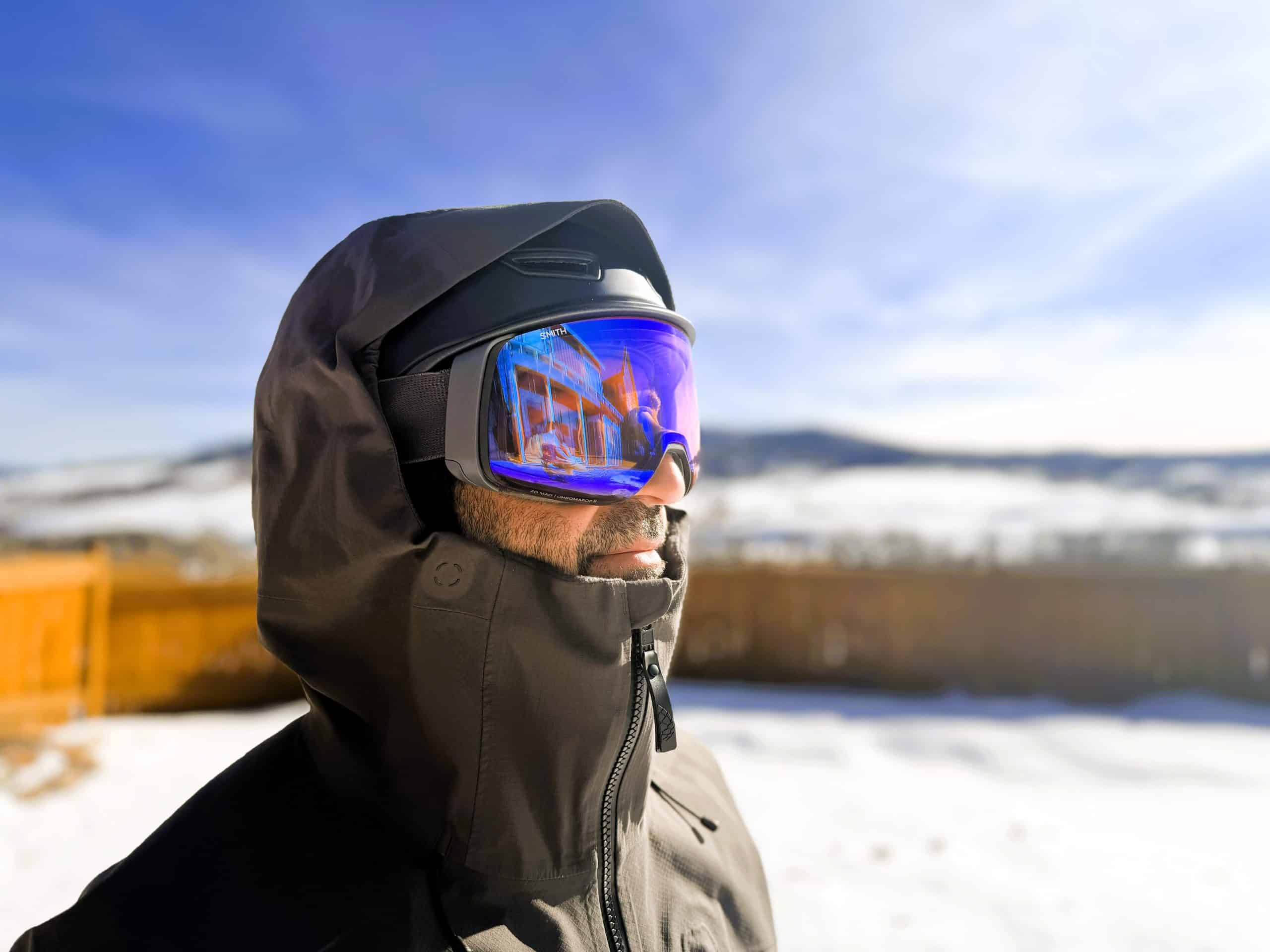 Man wearing the Stio Figment freeride ski jacket with the hood over his ski helmet.