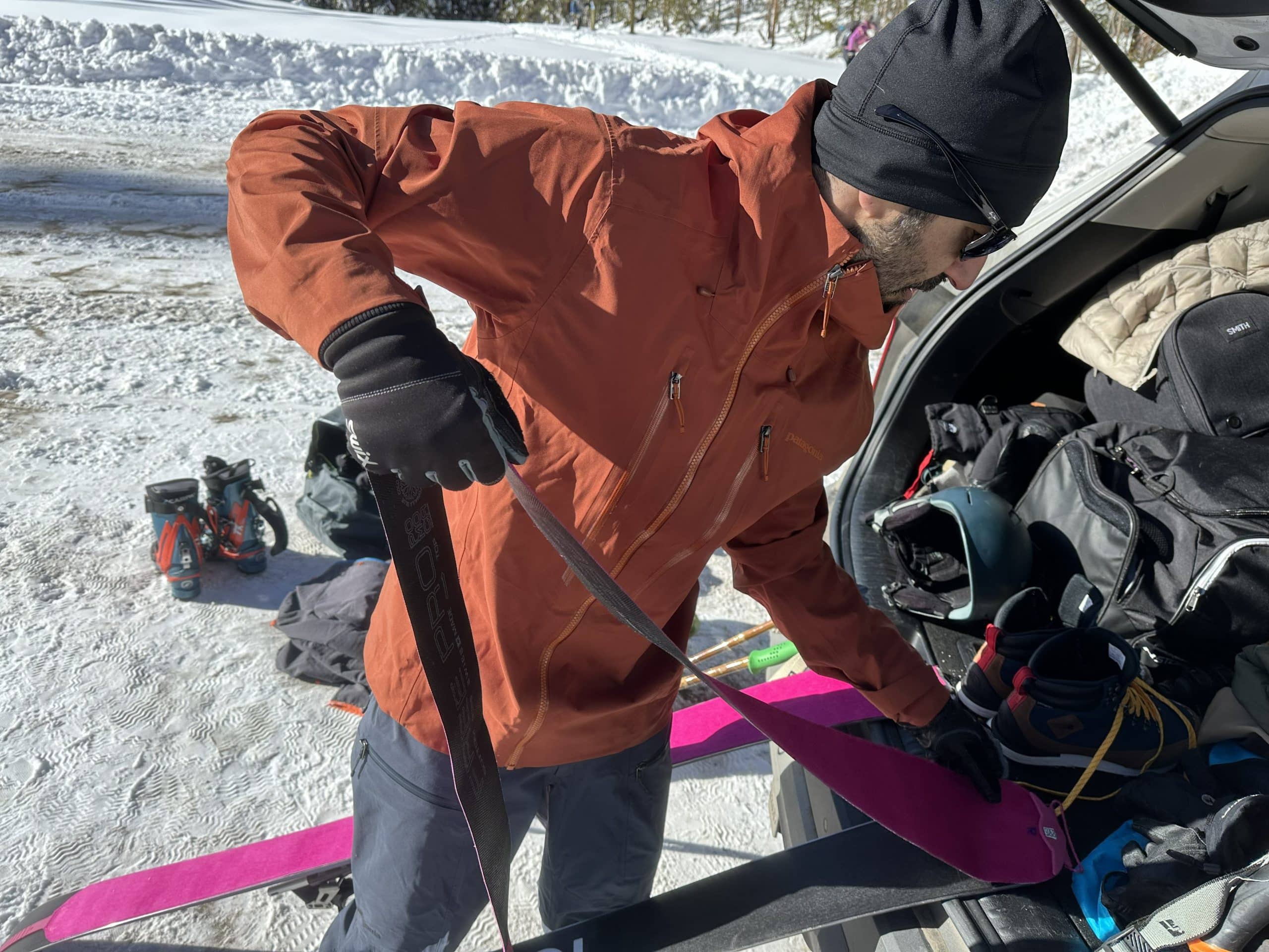 A man prepping for a ski tour wearing the Patagonia Stormstride jacket and pants.