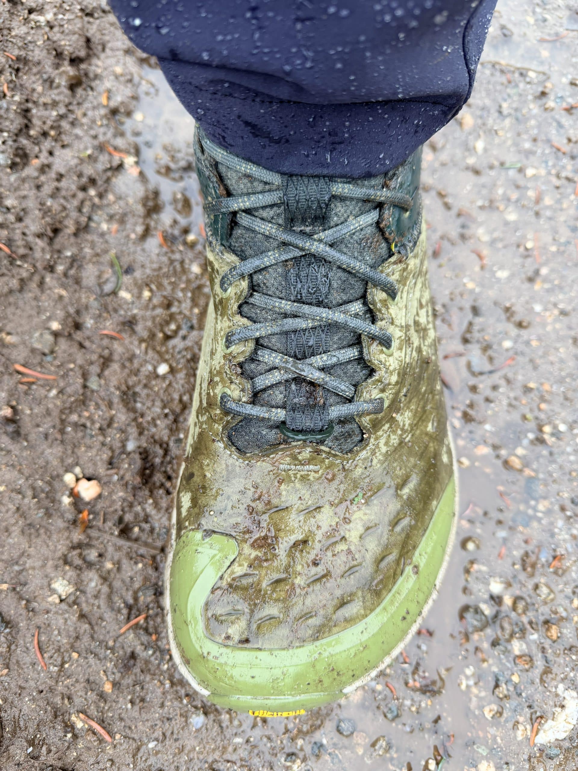A closeup of the Altra Olympus 6 hike mid GTX hiking boot, wet on a rainy hike.
