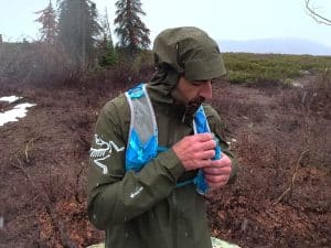 A trail runner wearing the Arc'teryx Norvan jacket in the rain.